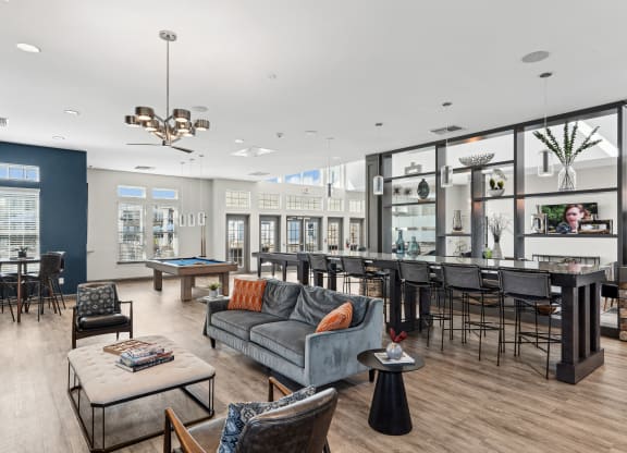 a living room with couches chairs and tables and a bar