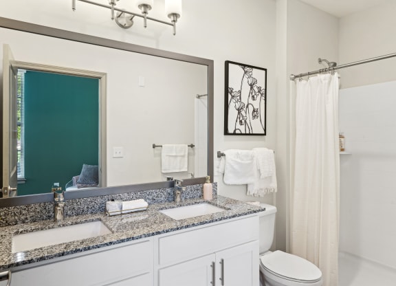 a white bathroom with two sinks and a mirror