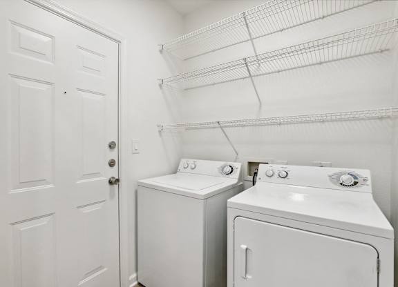 A white laundry room with a washer and dryer.