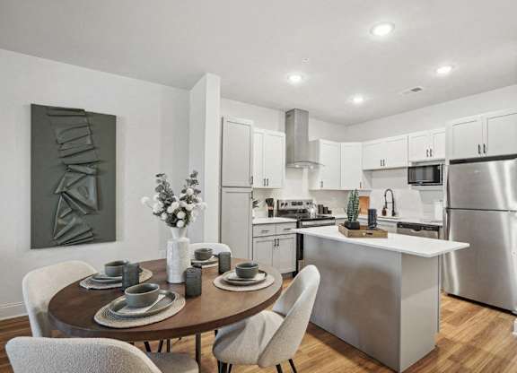A modern kitchen with a dining table set for two.