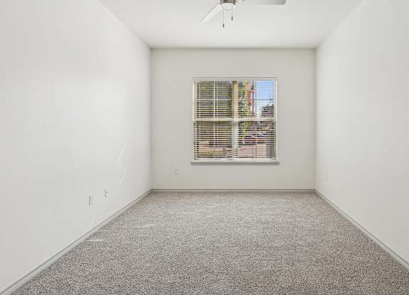 A room with a window and a ceiling fan.