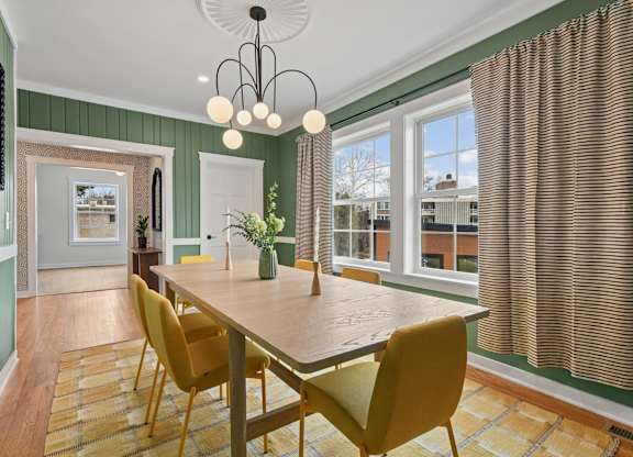 A dining room with a wooden table and yellow chairs.