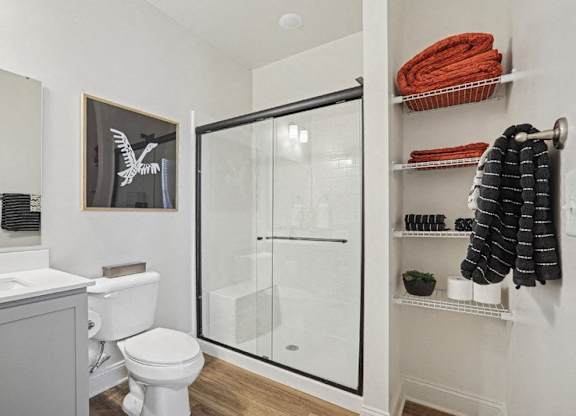 A white toilet sits next to a white sink in a bathroom.
