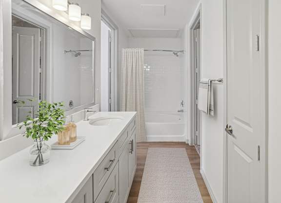 A bathroom with a white sink and a white tub.