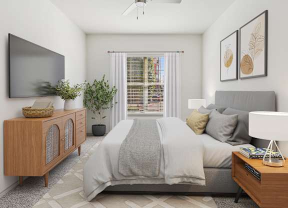 A bedroom with a bed, nightstand, and a television on the wall.