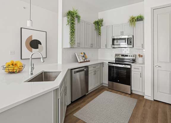 A modern kitchen with stainless steel appliances and white cabinets.