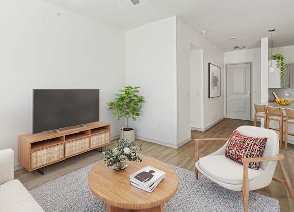 A living room with a television, a chair, a table, and a potted plant.