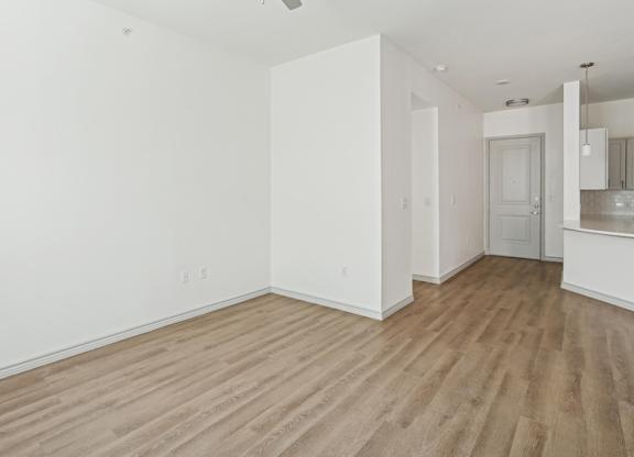 A room with wooden flooring and white walls.