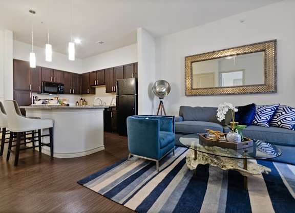 a living room and kitchen with a blue couch and a table
