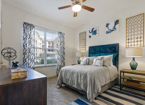 a bedroom with a bed and a ceiling fan