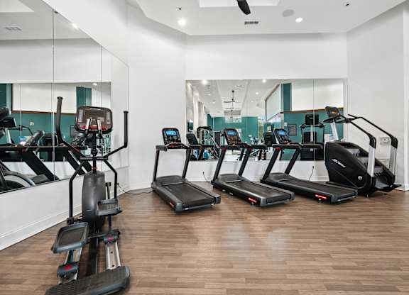 A gym with treadmills and elliptical machines.