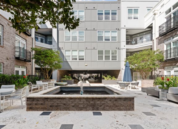 a courtyard with a fountain and tables and chairs