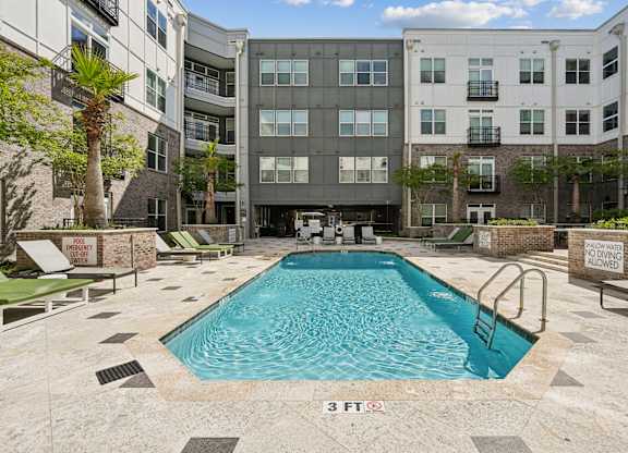 A pool in front of a building with a sign that says 3 feet.