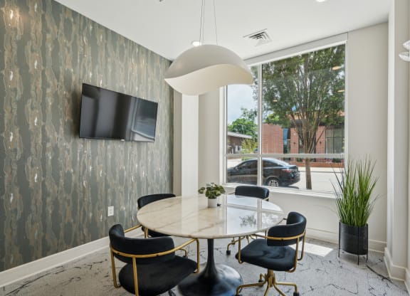 a dining room with a large window and a table and chairs