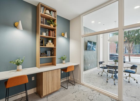 a home office with a desk and a large window