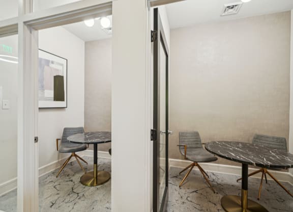 a meeting room with a table and chairs and a glass door
