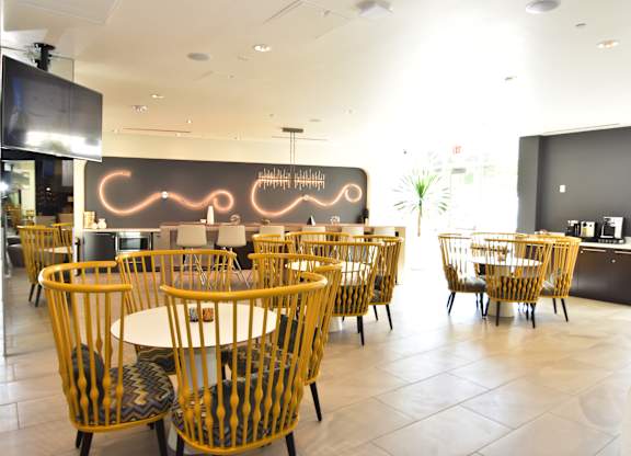 Community dining area with stylish yellow chairs at 360 Luxury Apartments, San Diego, CA 92122