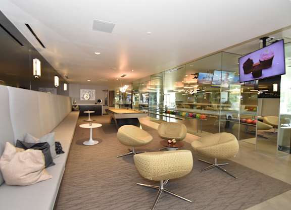 Game room with pool table and curved swivel seating at 360 Luxury Apartments, San Diego, California