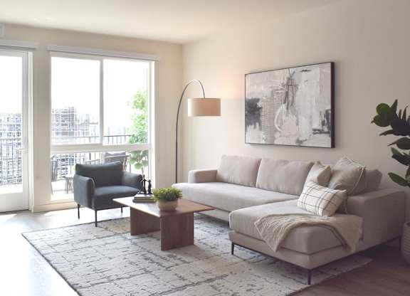 Living room with sectional sofa and balcony access at Garden at 3Roots Apartments, San Diego