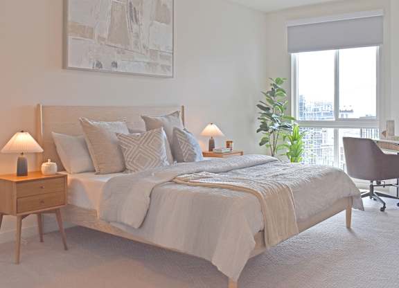 Bright bedroom with neutral tones and city views at Garden at 3Roots Apartments, San Diego