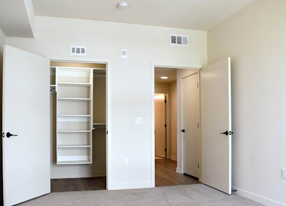 Bedroom with walk-in closet and hallway access at Garden at 3Roots Apartments, San Diego