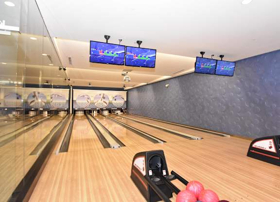 Bowling lanes with seating and overhead screens at Casa Mira View Apartments, San Diego, CA 92126