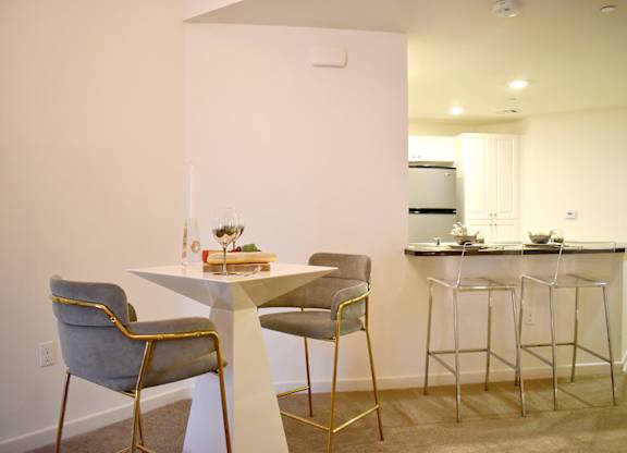 Dining table with modern chairs and kitchen bar at Casa Mira View Apartments, San Diego, California