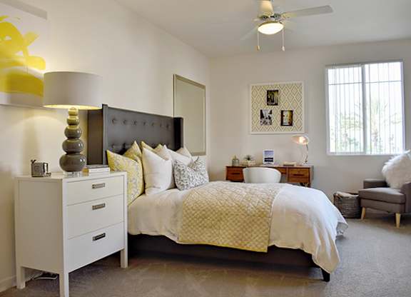 Bedroom with dark upholstered headboard and white bedding at Casa Mira View Apartments, San Diego