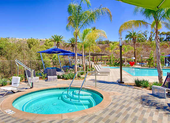 Circular spa with handrail and blue umbrellas at Casa Mira View Apartments, San Diego, CA