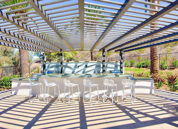 Outdoor dining area with pergola and seating at Casa Mira View Apartments, San Diego