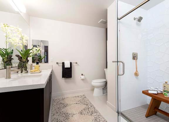 Modern bathroom with glass enclosed shower at Elements Apartments, California, 92612