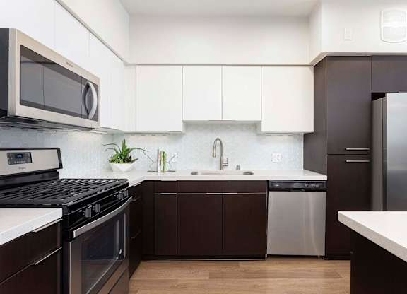 Contemporary kitchen with dark and white cabinets at Elements Apartments, Irvine, California
