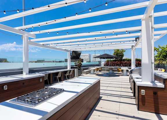 Rooftop outdoor kitchen with grills and pergola at Elements Apartments, Irvine, CA