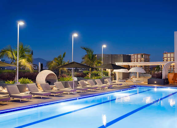 Lap pool with lounge chairs at dusk at Elements Apartments, California
