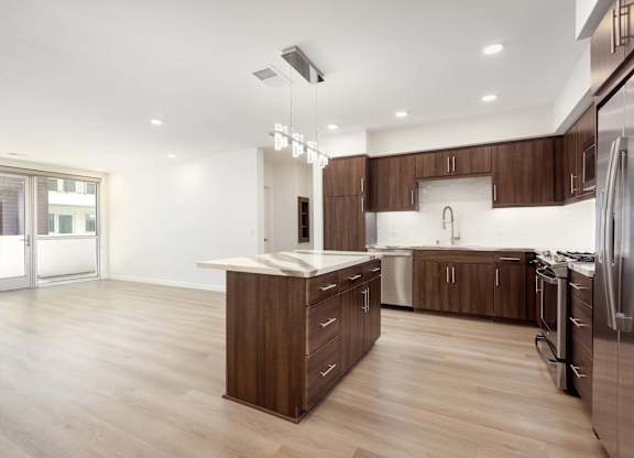 Open kitchen with island and light wood flooring at Elements Apartments, Irvine, 92612