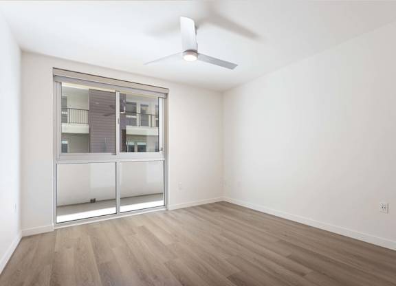 Bedroom with balcony access and ceiling fan at Elements Apartments, Irvine, California