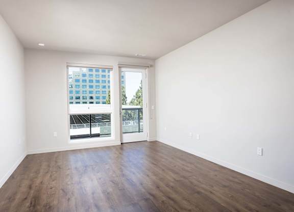 Empty room with balcony door and wood flooring at Elements Apartments, Irvine, California