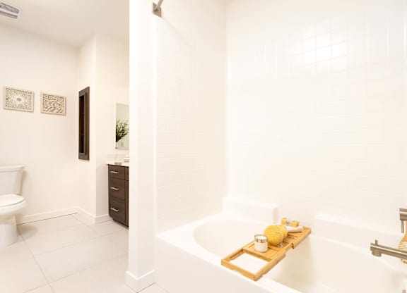 Spacious bathroom with soaking tub and white tile at Elements Apartments, California
