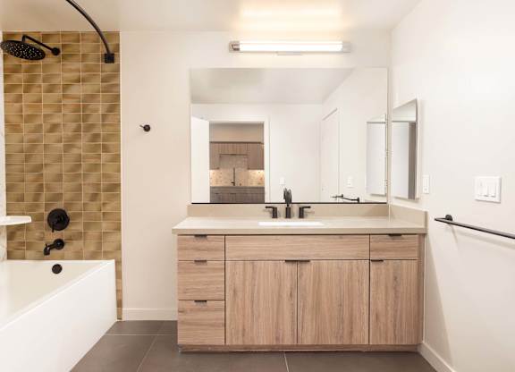 Bathroom with tiled tub shower and floating vanity at Elements Apartments, Irvine, California