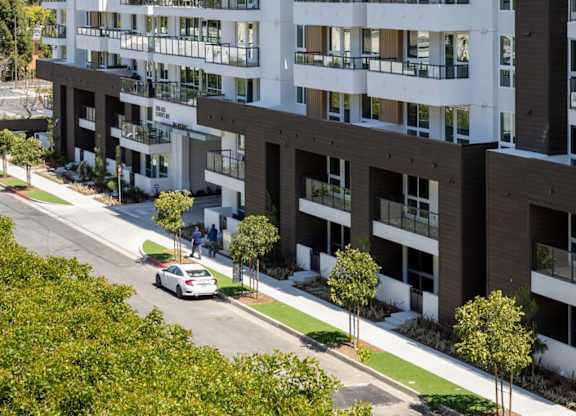 Modern apartment building with tree lined sidewalk at Elements Apartments, Irvine, 92612