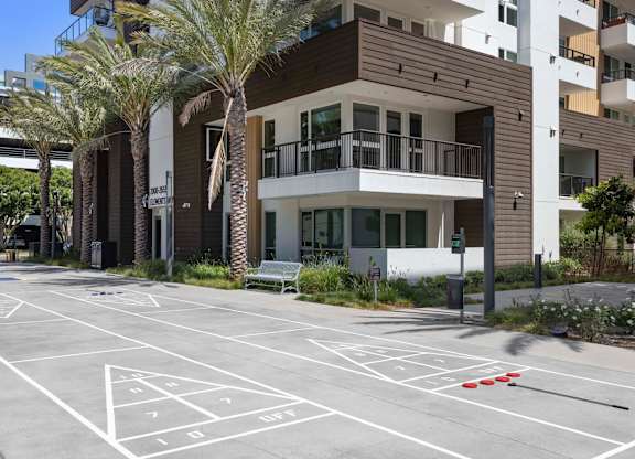 Shuffleboard court with parking and residential buildings at Elements Apartments, Irvine