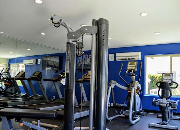 A gym with a variety of equipment including treadmills, stationary bikes, and weight machines.at La Jolla Canyon Apartments, San Diego, CA