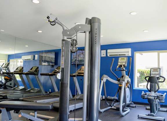 A gym with a variety of equipment including treadmills, exercise bikes, and weight machines.at La Jolla Canyon Apartments, California, 92121