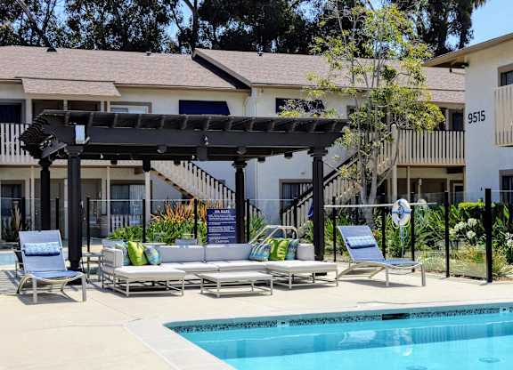 A pool area with sun loungers and a pergola.at La Jolla Canyon Apartments, San Diego