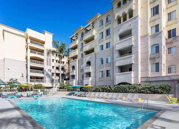 Swimming pool with lounge seating and umbrellas at La Jolla Crossroads Apartments, San Diego, 92122
