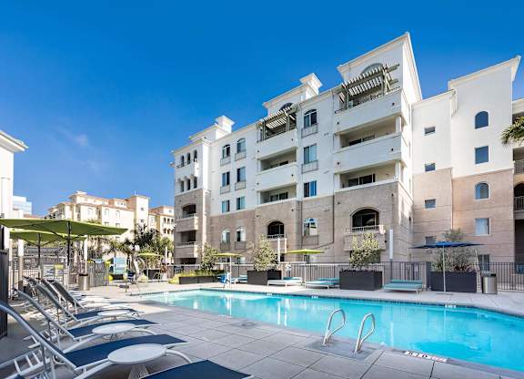 Swimming pool with sundeck and white buildings at La Jolla Crossroads Apartments, San Diego, California