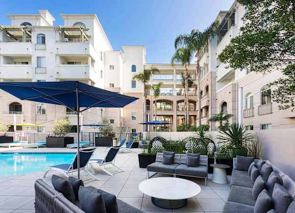 Pool area with cabanas and outdoor lounge seating at La Jolla Crossroads Apartments, San Diego
