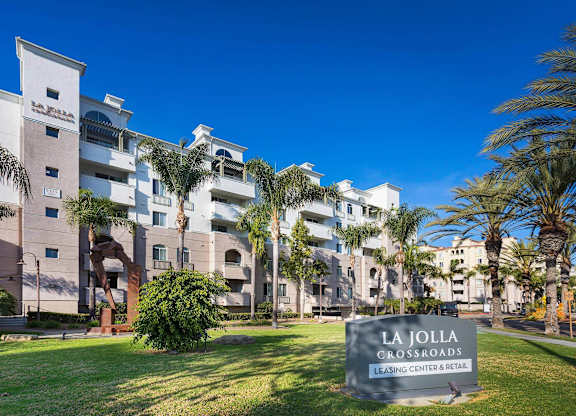 Community sign and sculpture on green lawn at La Jolla Crossroads Apartments, San Diego, California