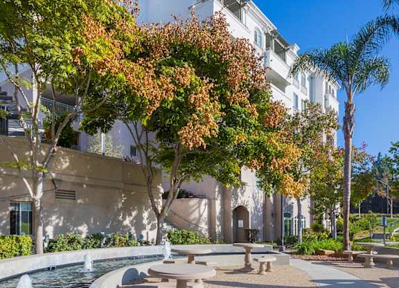 Courtyard fountain with circular seating area and trees at La Jolla Crossroads Apartments, California