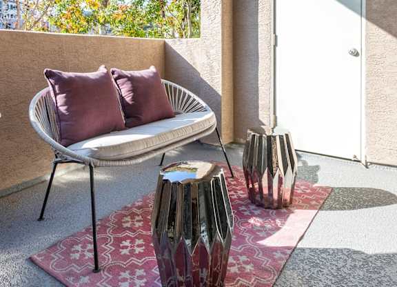 Covered balcony with modern chair and decorative accents at La Jolla Crossroads Apartments, San Diego, 92122